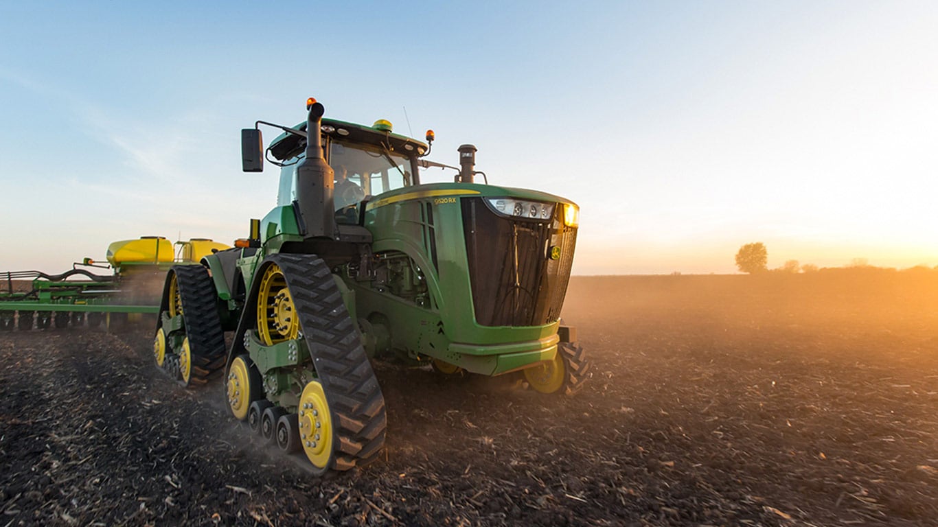 John Deere tractor equipped with planter tracks at work in the field
