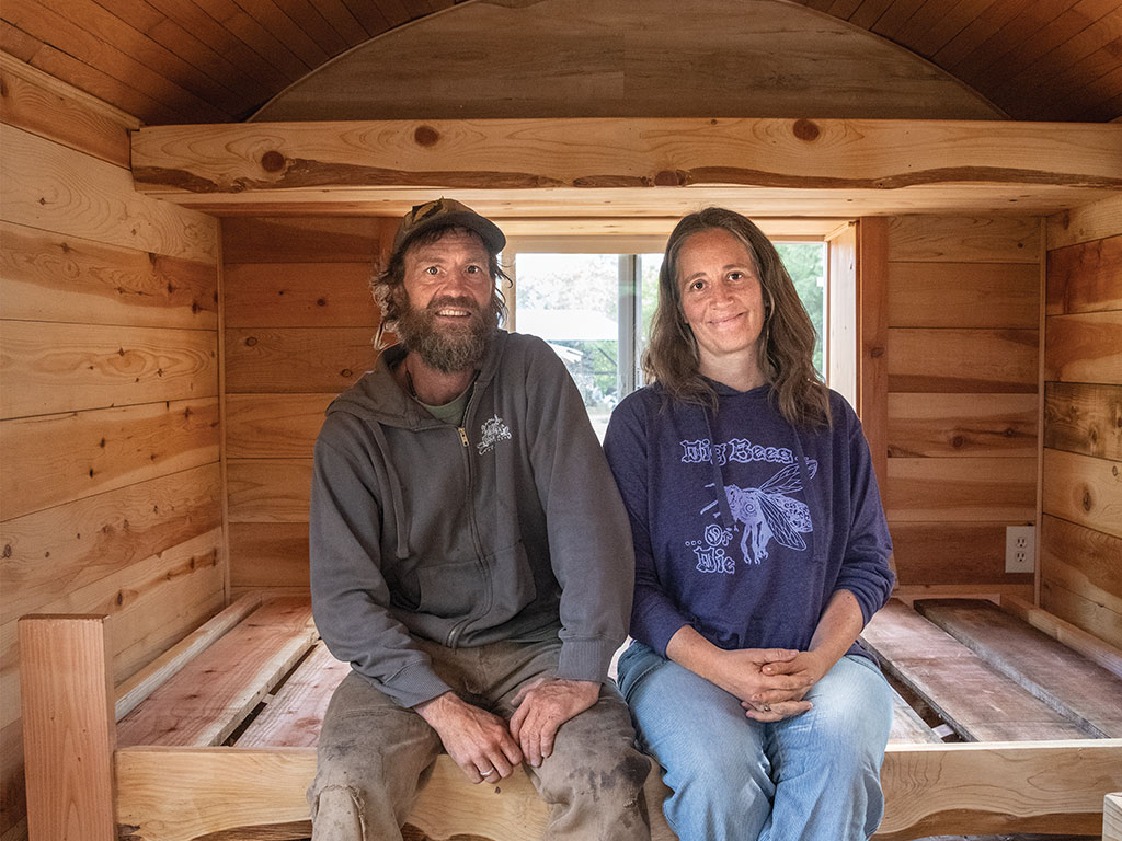Beekeeper couple sitting in their wooden hive hut